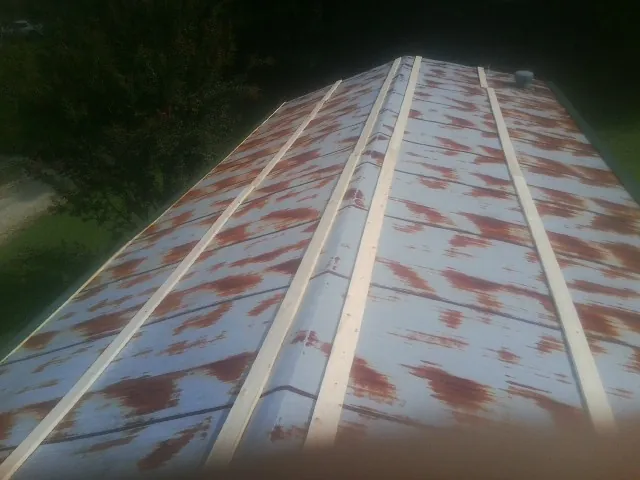 Rusted metal roof panels with new wood purlins before replacement — Storm Damage Roof Repair in Ellington by Roofing Brothers